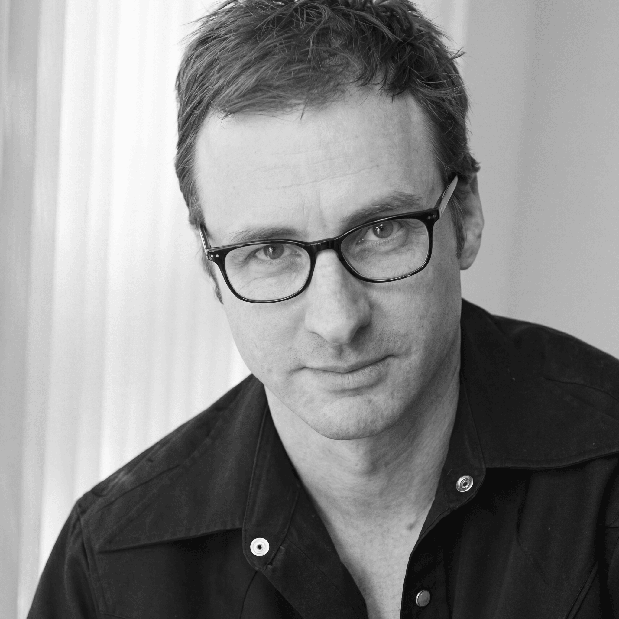 Hank Mann portrait in dark shirt with glasses